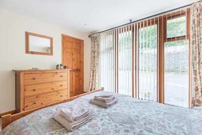 a bedroom with a bed and a large window at Hay Barn St Breock beautiful countryside views in Wadebridge
