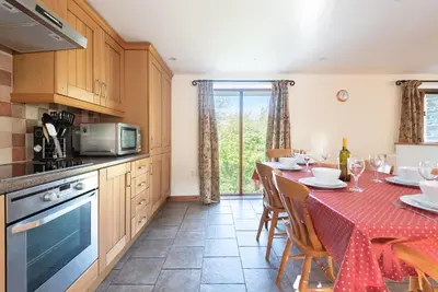 a kitchen with a table with a red table cloth at Hay Barn St Breock beautiful countryside views in Wadebridge