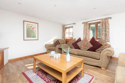 a living room with a couch and a table at Hay Barn St Breock beautiful countryside views in Wadebridge