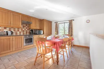 a kitchen with a table and chairs in a room at Hay Barn St Breock beautiful countryside views in Wadebridge