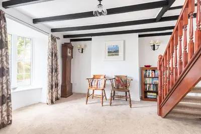 a living room with a table and two chairs at Fernleigh Cottage near the North Cornish beaches in Saint Mabyn