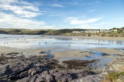 a group of people swimming in the water on a beach at Fernleigh Cottage near the North Cornish beaches in Saint Mabyn