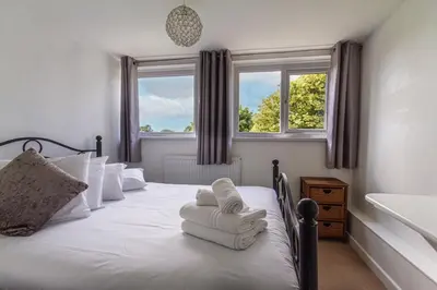 a bedroom with a bed with towels on it at Fourways near the golden sands of Marazion in Leedstown