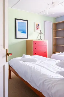 a bedroom with two beds and a red dresser at Fourways near the golden sands of Marazion in Leedstown