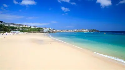 a view of a beach with people in the water at Fourways near the golden sands of Marazion in Leedstown