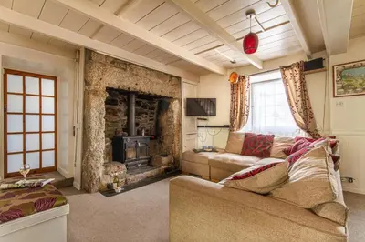 a living room with a couch and a fireplace at Fourways near the golden sands of Marazion in Leedstown
