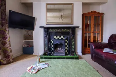 a living room with a fireplace and a tv at Fourways near the golden sands of Marazion in Leedstown