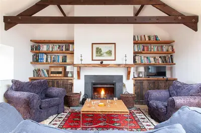 a living room with two couches and a fireplace at Carneggan Barn Lanteglos has breath taking views in Lanteglos