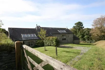 a house with a fence in front of it at Carneggan Barn Lanteglos has breath taking views in Lanteglos