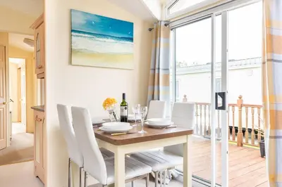 a dining room with a table and white chairs at Sunshine Retreat Wadebridge in Wadebridge