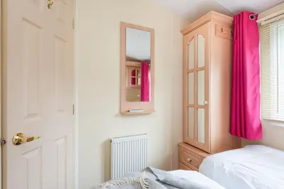 a bedroom with a bed and a mirror and a door at Sunshine Retreat Wadebridge in Wadebridge