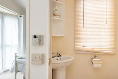 a bathroom with a sink and a toilet and a window at Sunshine Retreat Wadebridge in Wadebridge