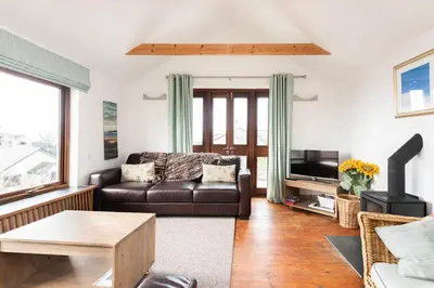 a living room with a couch and a tv at Cormorants Polruan village sea coastline views in Fowey