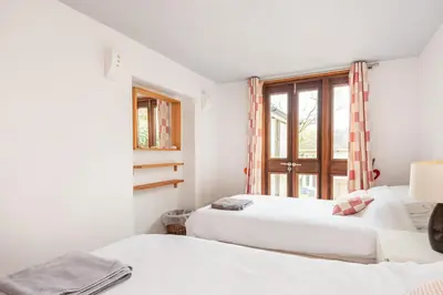 two beds in a room with a window at Cormorants Polruan village sea coastline views in Fowey