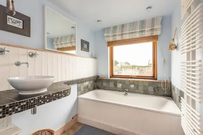 a bathroom with a tub and a sink and a window at Cormorants Polruan village sea coastline views in Fowey