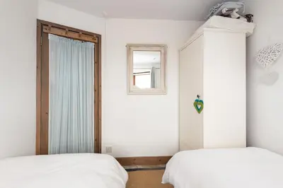 a bedroom with two beds and a window at Cormorants Polruan village sea coastline views in Fowey