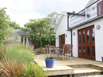 a patio with chairs and a table in front of a house at Cormorants Polruan village sea coastline views in Fowey