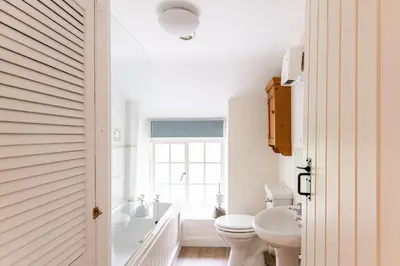 a bathroom with a tub and a toilet and a sink at Cuckoo Tor Lanteglos woodland coastline nearby in Lanteglos