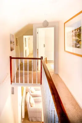 a staircase in a home with white walls at Cuckoo Tor Lanteglos woodland coastline nearby in Lanteglos