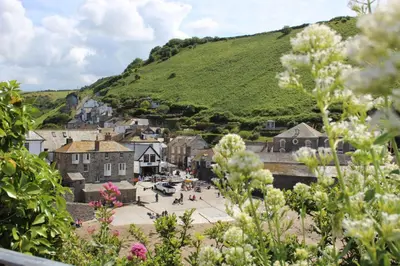 a view of a town with a hill in the background at Silvershell lovely views across Port Isaac in Port Isaac