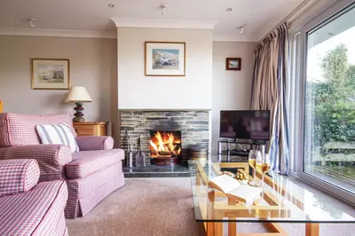 a living room with a couch and a fireplace at Silvershell lovely views across Port Isaac in Port Isaac