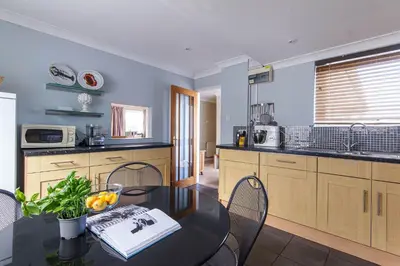 a kitchen with a table with a bowl of oranges on it at Silvershell lovely views across Port Isaac in Port Isaac