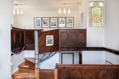 a staircase in a church with a stained glass window at Organ Loft North Coast moorland on the doorstep in Saint Breward