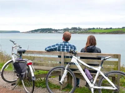 a man and a woman sitting on a bench with bikes at Organ Loft North Coast moorland on the doorstep in Saint Breward