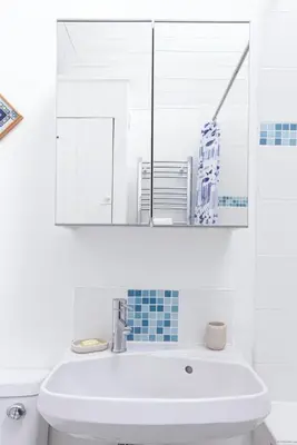 a white bathroom with a sink and a mirror at Organ Loft North Coast moorland on the doorstep in Saint Breward