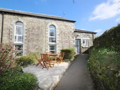a patio with a table and chairs in front of a building at Organ Loft North Coast moorland on the doorstep in Saint Breward