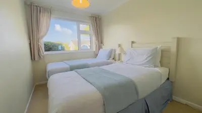 a bedroom with two beds and a window at Seamist Rock - on the north coast of Cornwall in Roche