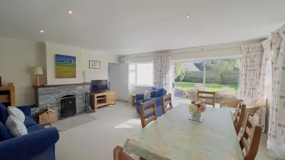 a living room with a table and a fireplace at Seamist Rock - on the north coast of Cornwall in Roche