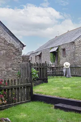 a wooden fence in front of a stone house at Rowan Cottage - sleeps 2 - Nr Looe and Polperro in Lanreath