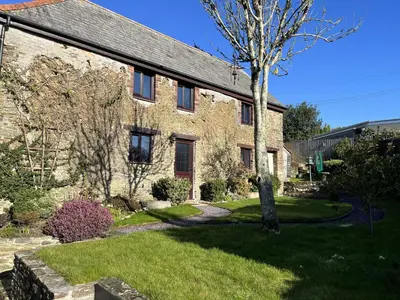 a brick house with a tree in the yard at Rowan Cottage - sleeps 2 - Nr Looe and Polperro in Lanreath