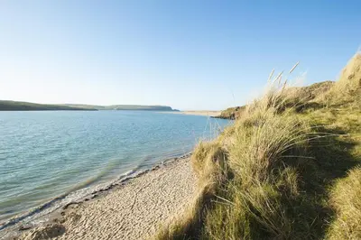 a sandy beach next to a body of water at The Loft in Wadebridge