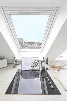 a room with a skylight and a table with a window at The Loft in Wadebridge