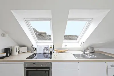 a kitchen with two windows and a sink at The Loft in Wadebridge