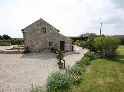 a stone house with a yard with flowers at Thumbelina far reaching views of the countryside in Budock Water