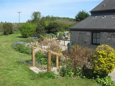 a garden with a wooden fence in front of a house at Thumbelina far reaching views of the countryside in Budock Water