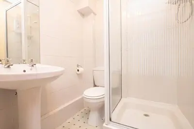 a bathroom with a toilet and a sink and a shower at Thumbelina far reaching views of the countryside in Budock Water