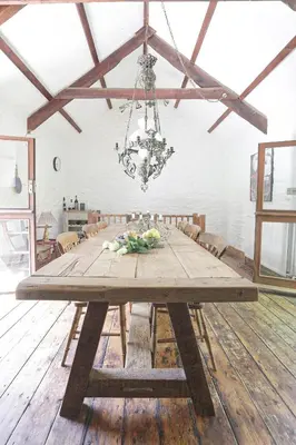 a dining room with a wooden table with a chandelier at The Barn in Camelford