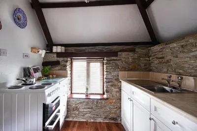 a kitchen with a sink and a stone wall at Rowan Retreat - sleeps 2 - Nr Looe and Polperro in Lanreath