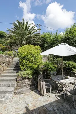 an umbrella and a table and chairs and stairs at Sail Loft — A quiet St Mawes gem in Saint Mawes