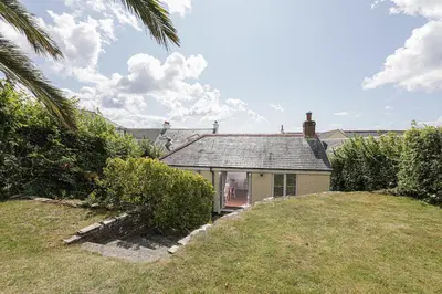 a small house on a hill with a yard at Sail Loft — A quiet St Mawes gem in Saint Mawes