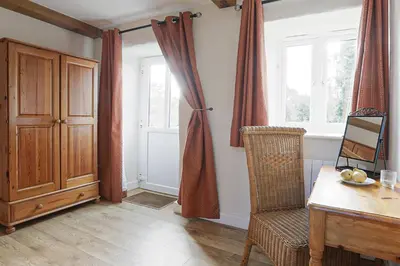 a room with a desk and a chair and a window at Trotters barn conversion on edge of Mount Hawke in Mount Hawke