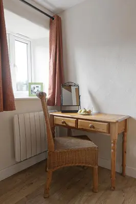 a wooden desk with a chair and a mirror at Trotters barn conversion on edge of Mount Hawke in Mount Hawke