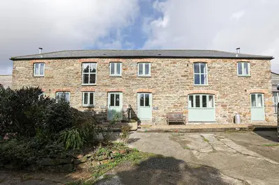 a large brick house with white doors and windows at Trotters barn conversion on edge of Mount Hawke in Mount Hawke