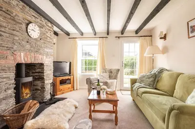 a living room with a couch and a fireplace at Rosemary Cottage Edmonton set in the countryside in Wadebridge