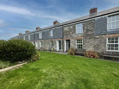 a large brick building with a lawn in front of it at Rosemary Cottage Edmonton set in the countryside in Wadebridge