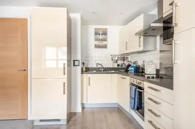 a kitchen with white cabinets and a sink at Zephyr in Fowey